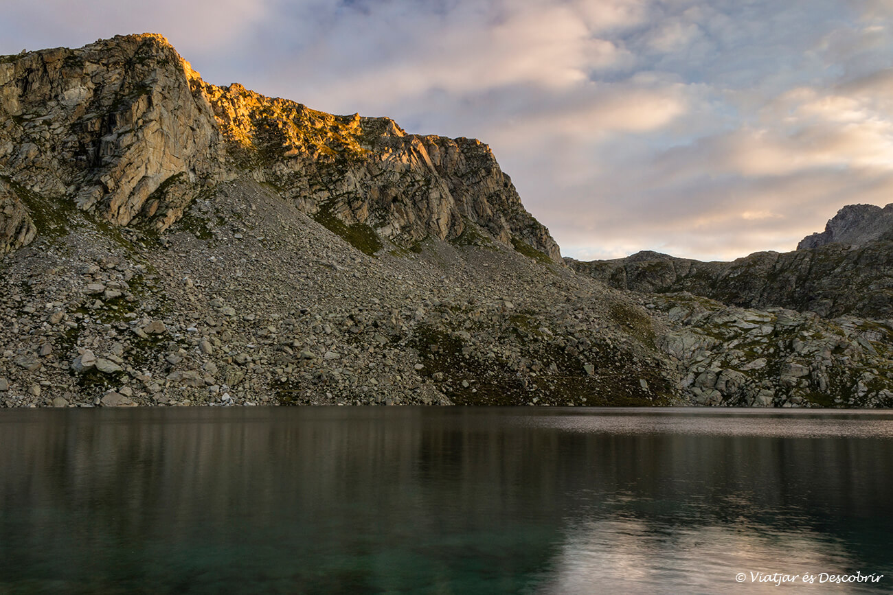 luces del amanecer junto al estany de colomina durante la ruta de trekking de carros de foc en el pirineo