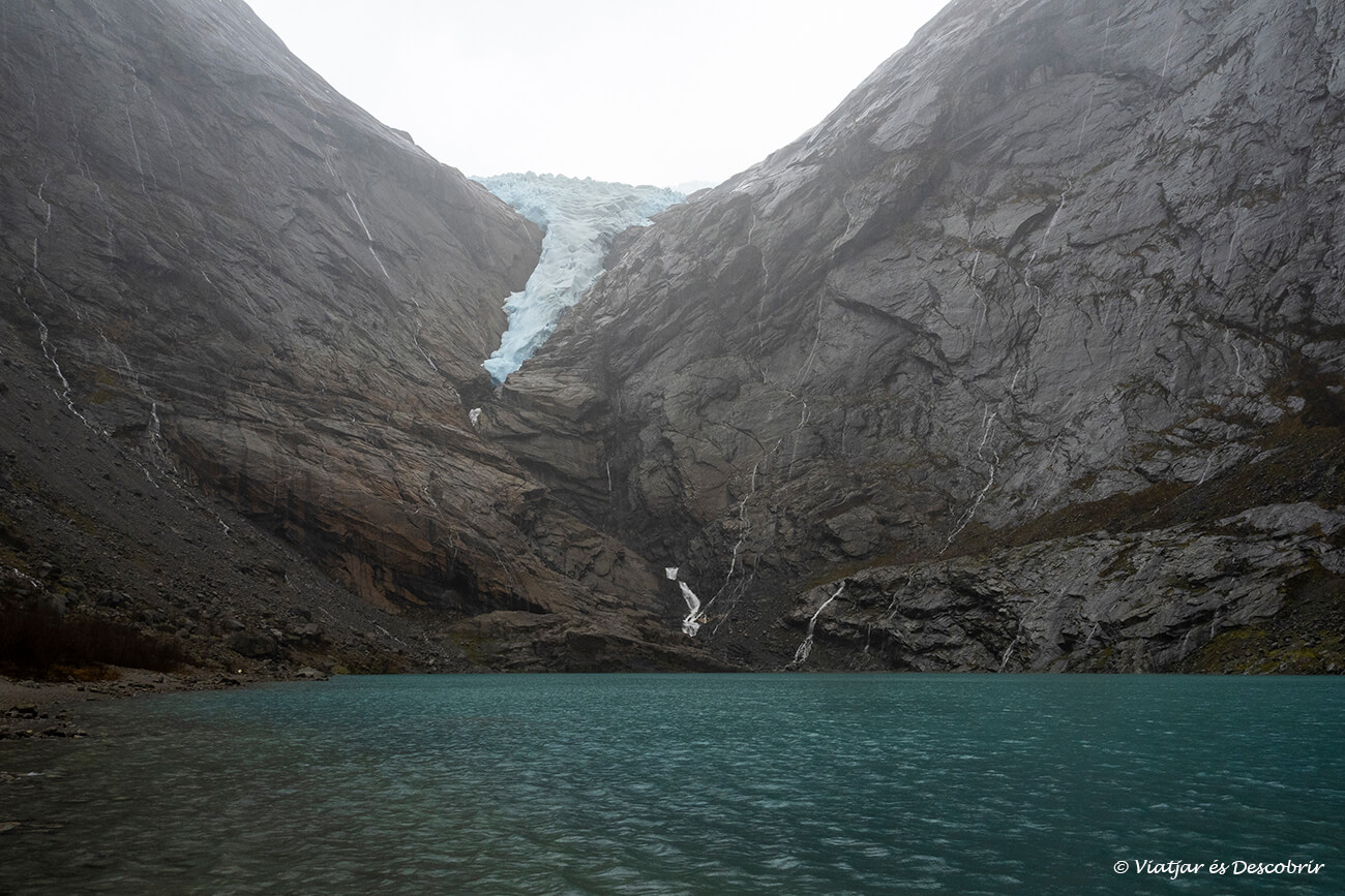 el glaciar Briksdal y el lago turquesa que se nutre del agua del deshielo del hielo durante un frío día de invierno en el pueblo de Olden en Noruega
