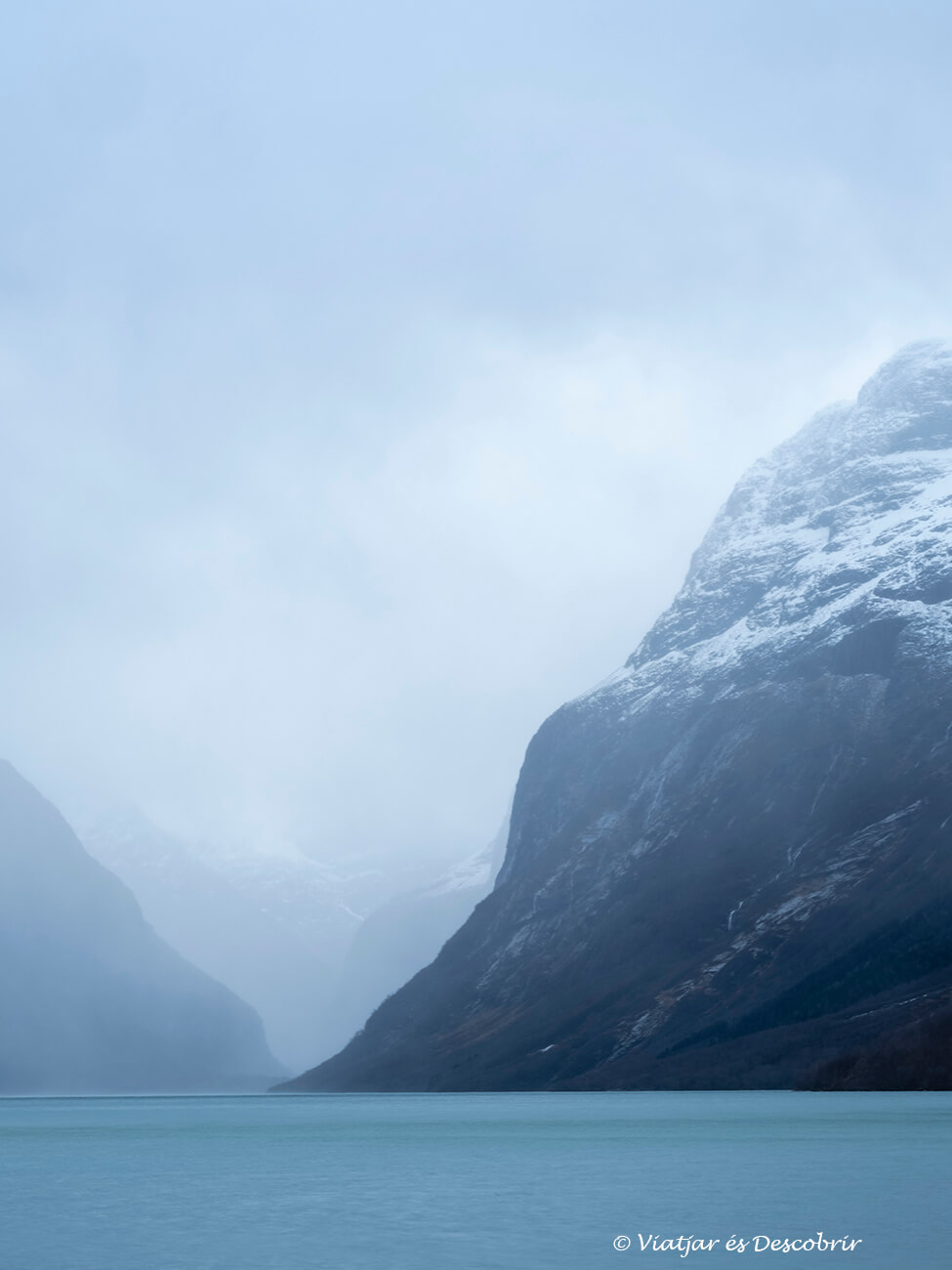 el agua azul del Lago de Loen y las montañas nevadas que lo rodean durante un día de mucho viento en los fiordos noruegos