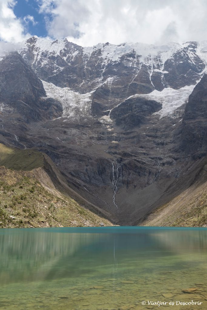 viajar a Perú para libre y hacer trekkings: laguna humantay durante un día con nubes al inicio del trekking del Salkantay