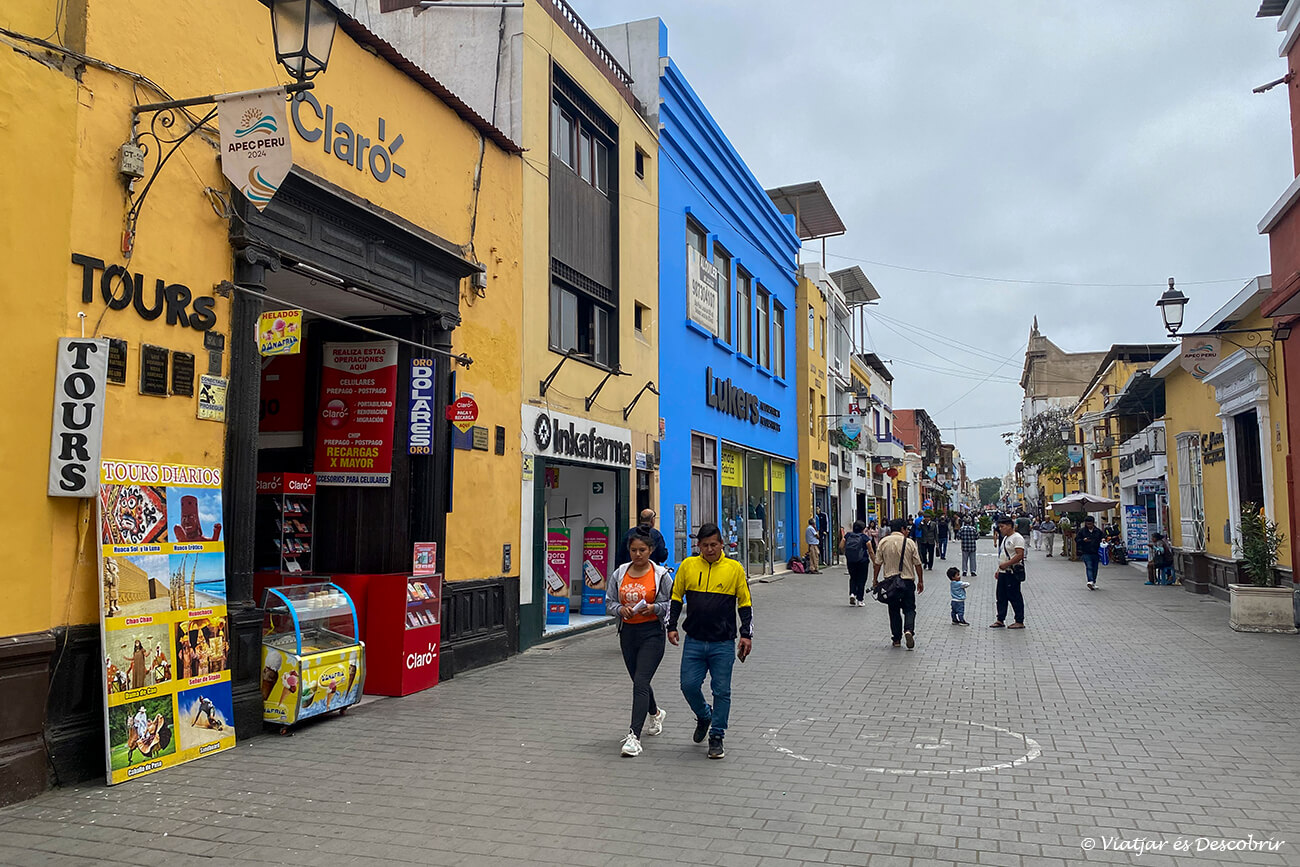 calle céntrica en la ciudad de Trujillo con comercios y gente paseando