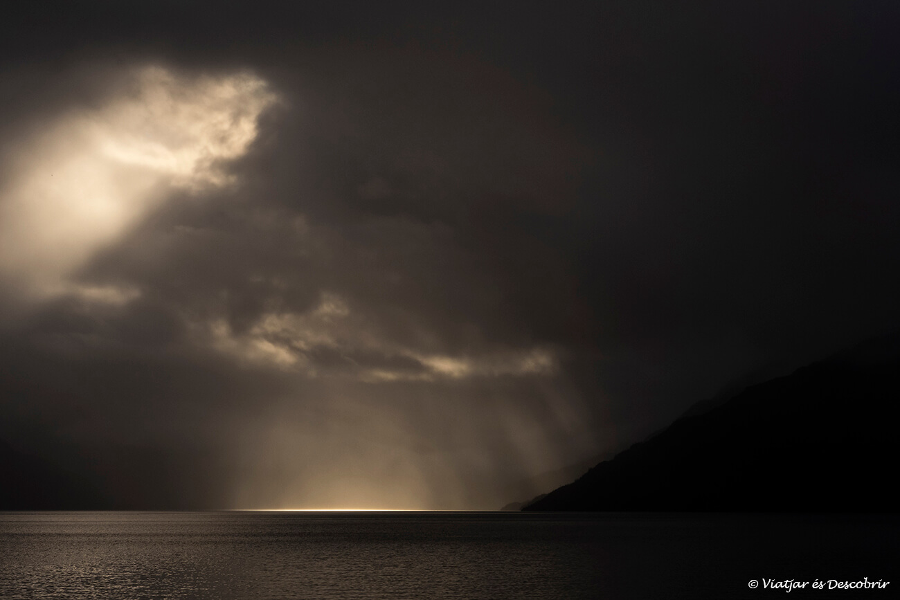 luces dramáticas al amanecer cruzando en barcaza el fiordo mitchell al final de la carretera austral