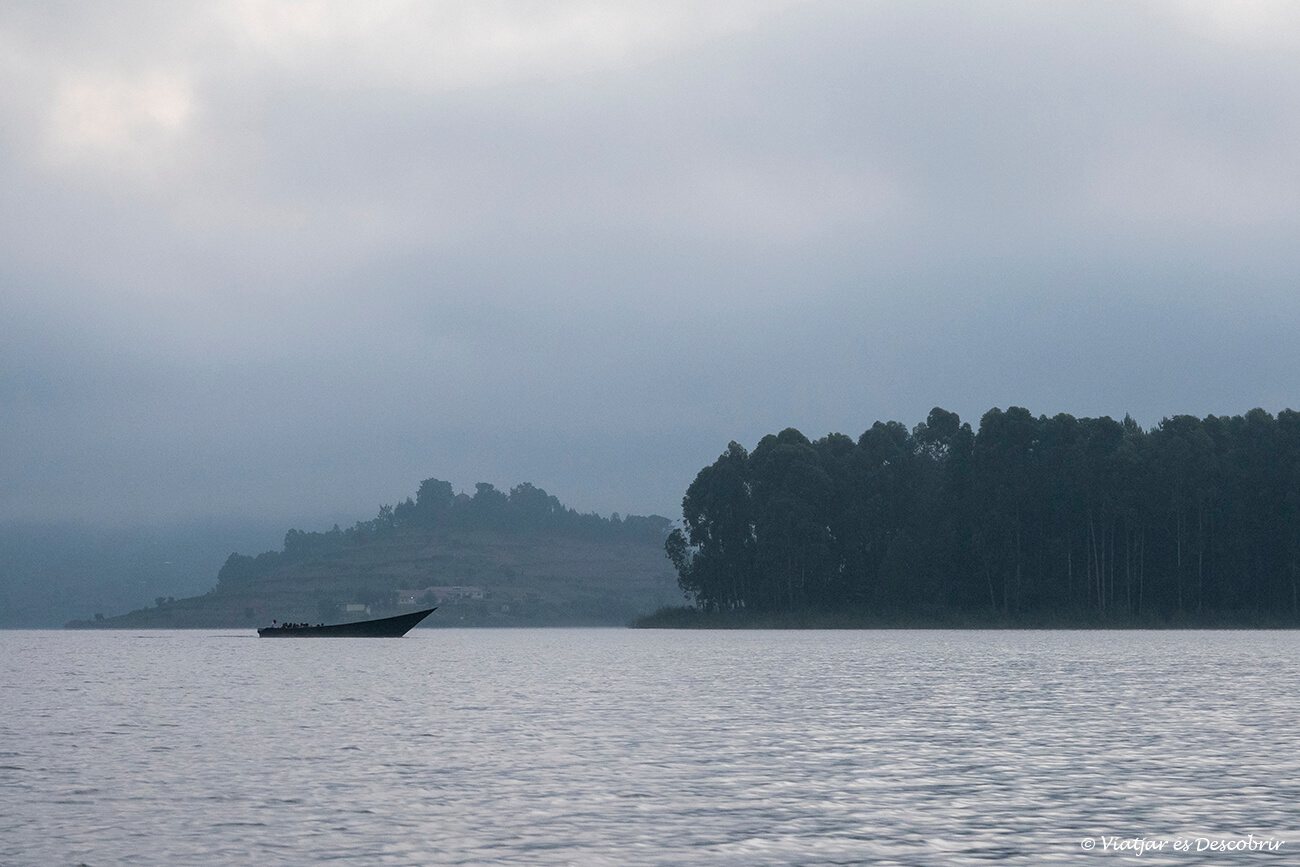 paisaje típico del lago Bunyonyi con una barca y las islas llenas de vegetación